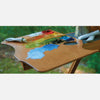 New Wave Handcrafted Maple Wood Highland Ergonomic Hand Held Landscape Artist Paint Palette with oil paint outdoors on a landscape pochade box