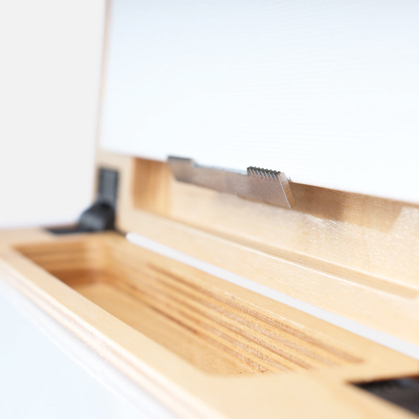 u.go Plein Air Anywhere Pochade Box, 11" x 14.5" model, bottom teeth of panel holder gripping a canvas panel