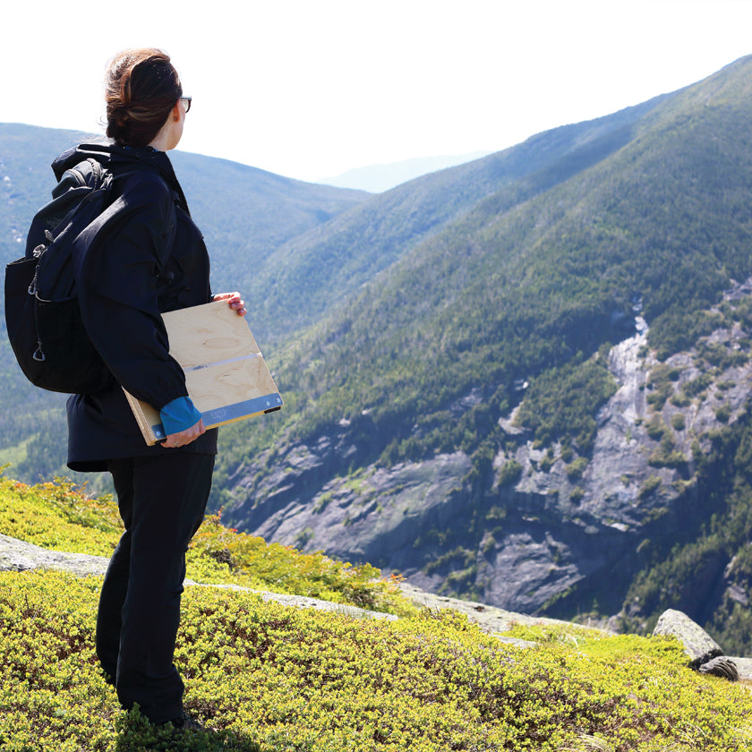 u.go Plein Air Anywhere Pochade Box, 11" x 14.5" model, being held on mountain while plein air landscape painting